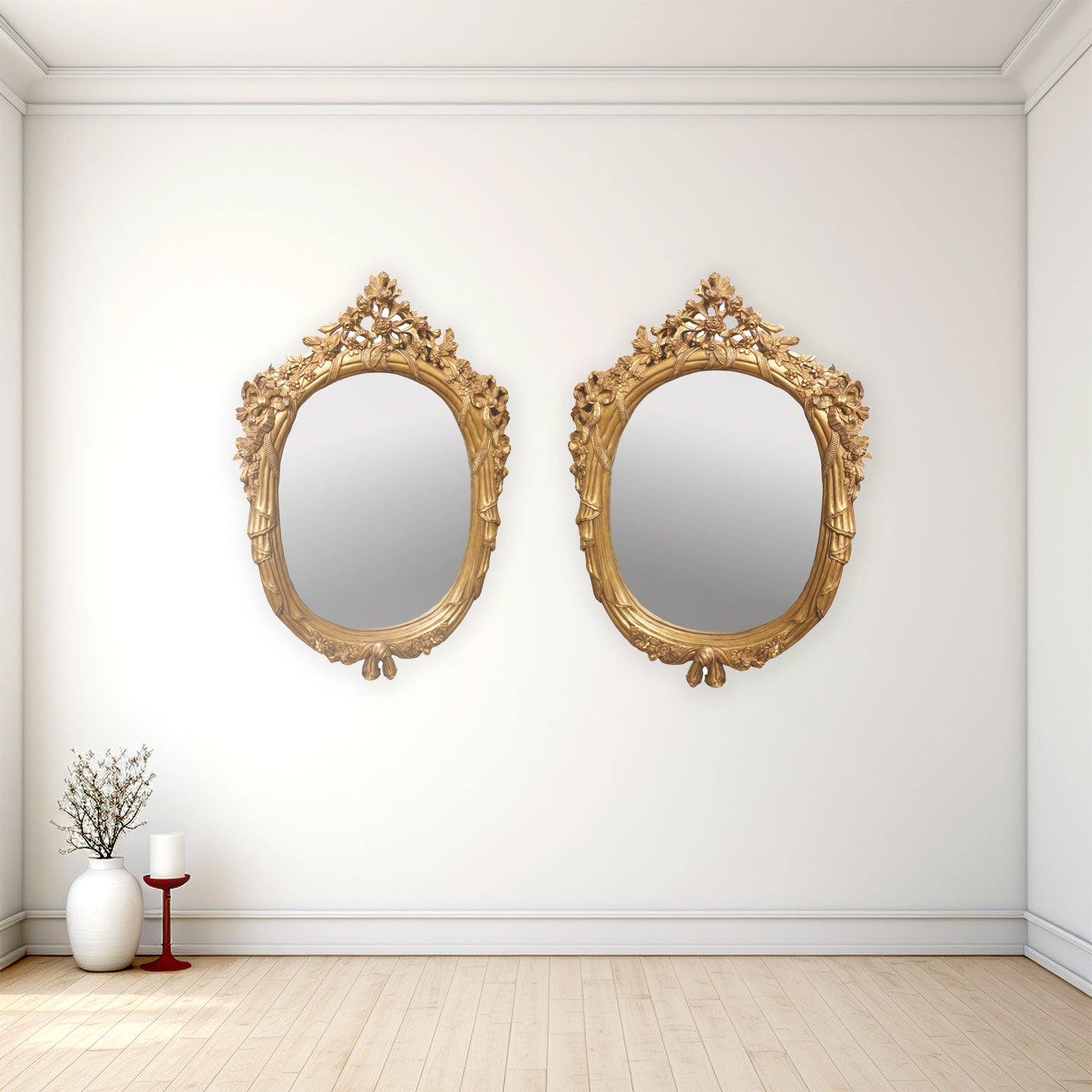 Two ornate gold mirrors on a white wall with a minimalistic decor.
