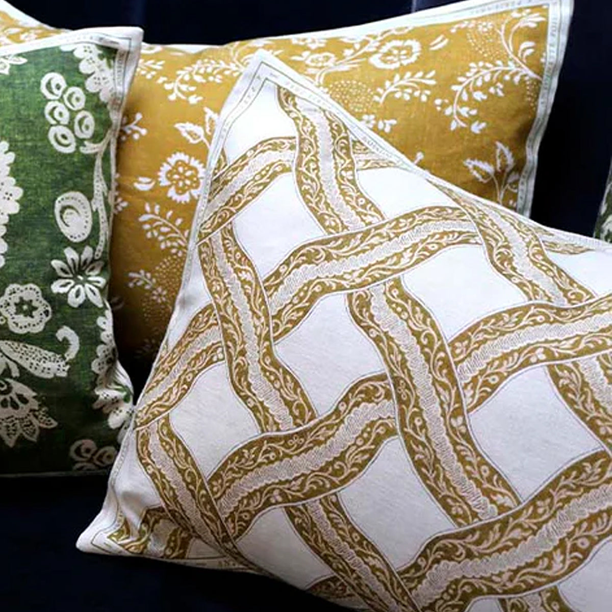 Three decorative pillows with different patterns on a dark background