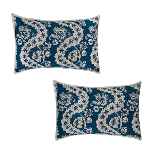Two blue pillows with white floral patterns on a white background