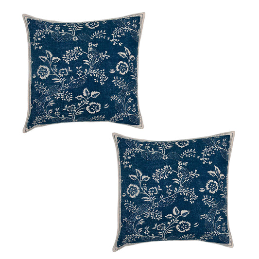 Two blue pillows with white floral patterns on a white background